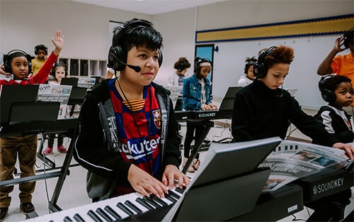 children playing pianos in a lab