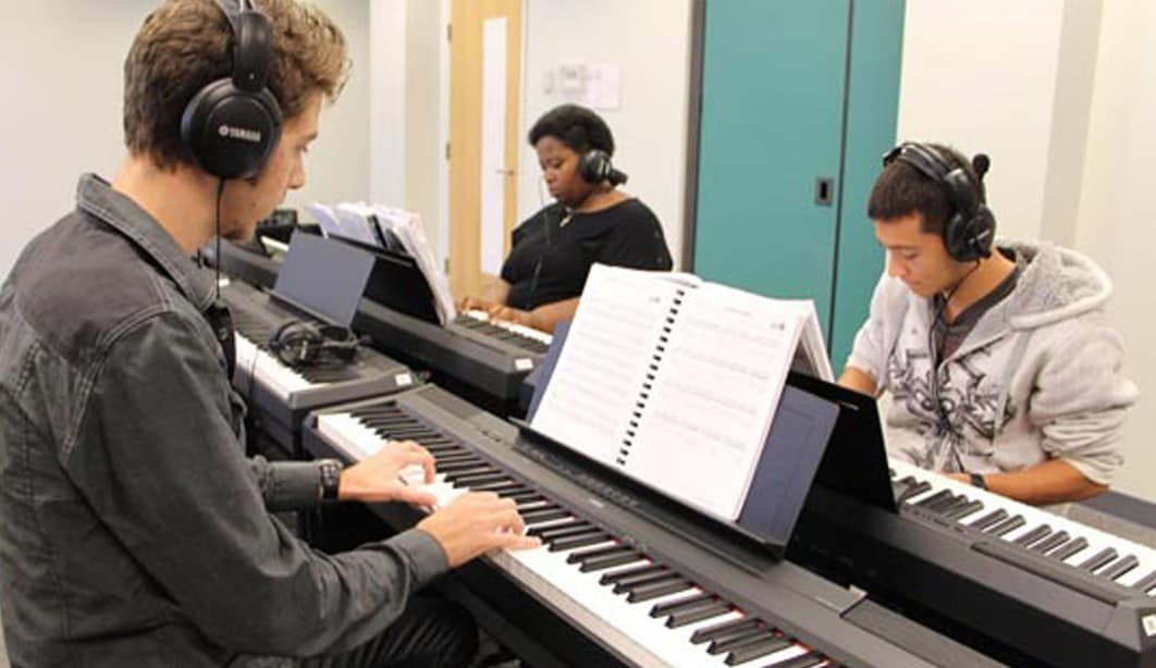 students in a piano lab playing piano